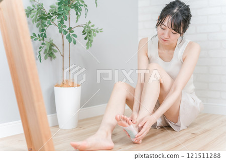 Asian woman who sticks a tree sheet to prevent swelling on her legs and calves (foot care) Asian woman who sticks a tree sheet to prevent swelling on her legs and calves (foot care) 121511288