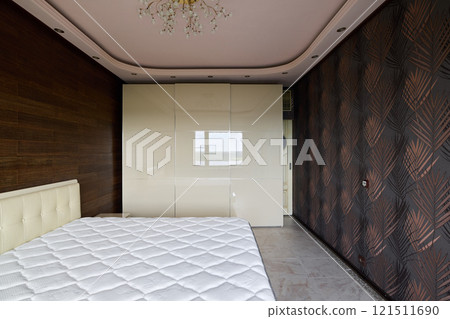 A contemporary and spacious bedroom designed with an elegant and stylish decor scheme A contemporary and spacious bedroom designed with an elegant and stylish decor scheme 121511690