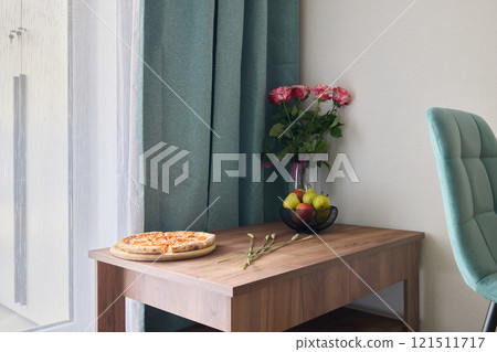 Experience a Cozy Dining Corner adorned with delicious Pizza and Fresh Flowers for ambiance 121511717