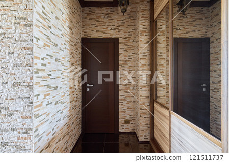 A modern hallway with decorative walls and a stylish mirror enhances the homes ambiance A modern hallway with decorative walls and a stylish mirror enhances the homes ambiance 121511737