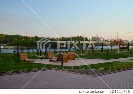 A Scenic Park with a River View and Relaxing Benches for visitors to enjoy nature 121511766