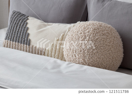 Cozy and Textured Pillows Beautifully Arranged on a Stylish Modern Bed for Comfort and Aesthetics 121511786
