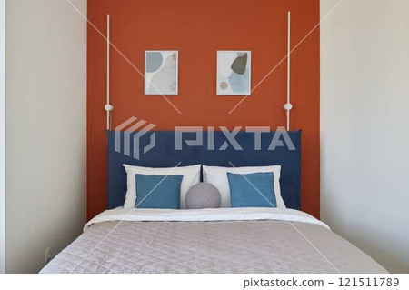 A modern cozy bedroom with stylish decor and warm tones, perfect for relaxation and rest 121511789