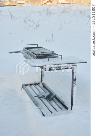 A Lovely SnowCovered Grill Set Against a Beautiful and Charming Winter Landscape Scene A Lovely SnowCovered Grill Set Against a Beautiful and Charming Winter Landscape Scene 121511807