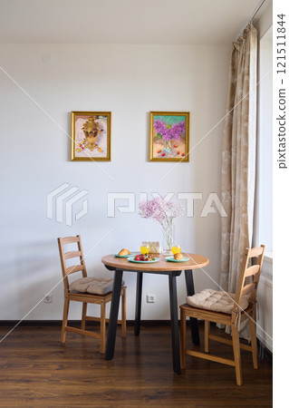 A Cozy and Inviting Dining Space Enhanced by a Beautiful Floral Arrangement and Art A Cozy and Inviting Dining Space Enhanced by a Beautiful Floral Arrangement and Art 121511844