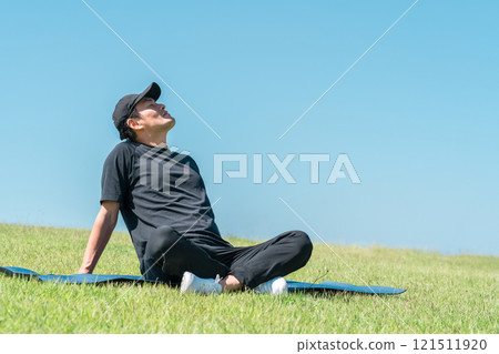 A man taking a deep breath and refreshing in the park (exercise, pilates, workout, yoga, sports) A man taking a deep breath and refreshing in the park (exercise, pilates, workout, yoga, sports) 121511920