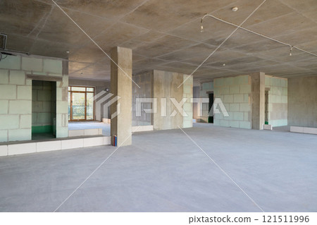 This spacious unfinished interior has concrete walls and an open layout for flexible future design 121511996