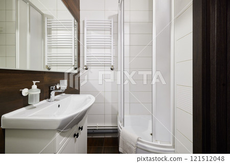 A modern bathroom interior featuring a stylish shower and a sleek, contemporary sink design 121512048