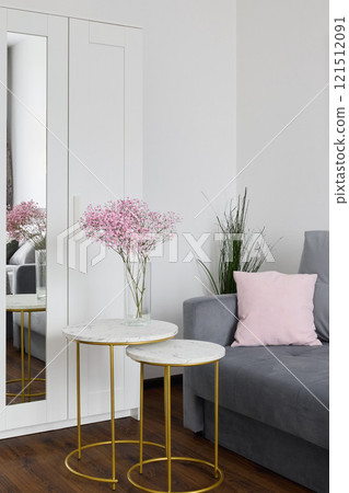 A stylish living room with modern furniture and a floral arrangement enhancing the ambiance 121512091