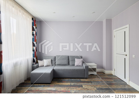 Discover a modern living room with a stylish gray sofa and bright, large windows Discover a modern living room with a stylish gray sofa and bright, large windows 121512099