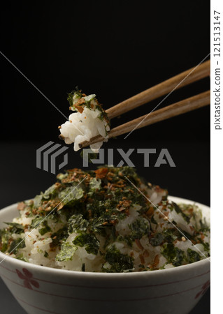 用筷子夾起撒有香鬆的米飯 用筷子夾起撒有香鬆的米飯 121513147