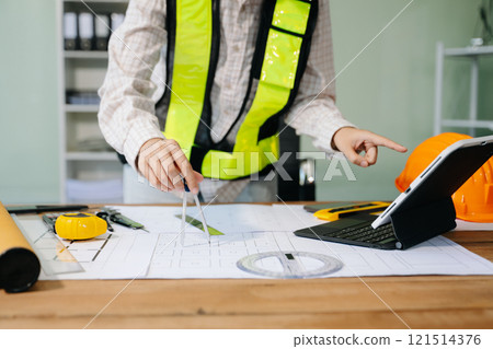 Businessman hand working and laptop with on on architectural project at construction site Businessman hand working and laptop with on on architectural project at construction site 121514376