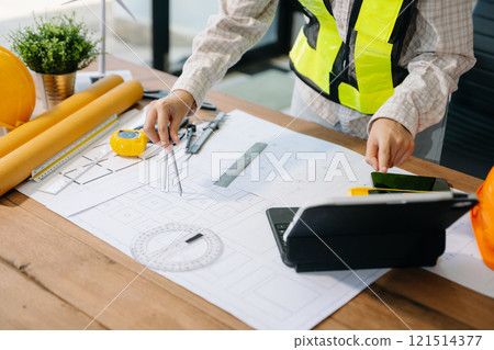 Businessman hand working and laptop with on on architectural project at construction site Businessman hand working and laptop with on on architectural project at construction site 121514377