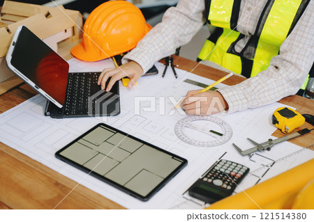 Businessman hand working and laptop with on on architectural project at construction site Businessman hand working and laptop with on on architectural project at construction site 121514380