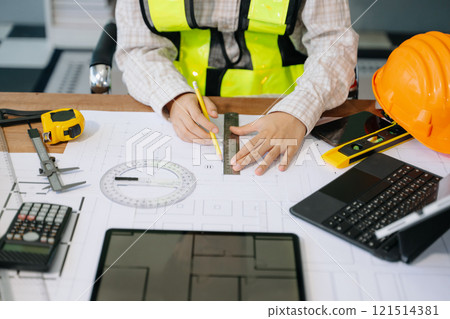 Businessman hand working and laptop with on on architectural project at construction site Businessman hand working and laptop with on on architectural project at construction site 121514381