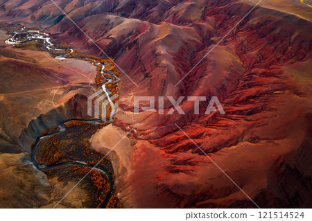Aerial view of vibrant red mountain valley with flowing river and forest 121514524