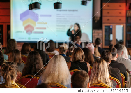 Audience attending a seminar with a speaker presenting on stage 121514525
