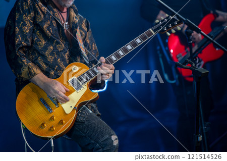 Guitarist performing live on stage under dramatic lighting Guitarist performing live on stage under dramatic lighting 121514526