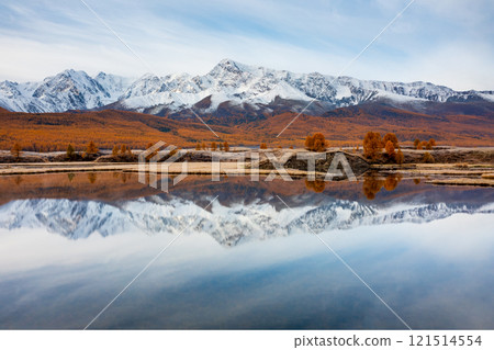 Scenic mountain range reflected on calm lake with autumnal forest around 121514554