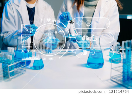 scientists in lab coats conducting research, handling glassware, and working with chemicals 121514764
