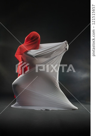 Creative fabric art performance with flowing materials in a studio setting 121515657