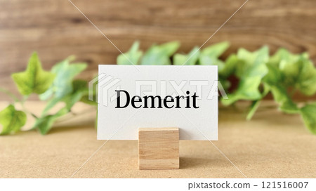 Demerit lettering card and ivy on brown board background 121516007