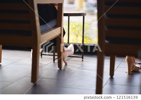 Chair and high heels illuminated by the light coming from the window 121516139