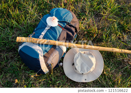 Backpack, hat and walking stick lying on grass during Camino de Santiago pilgrimage 121516622