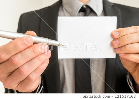Businessman holding out a blank card and pen 121517168