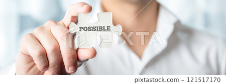 Businessman holding puzzle piece with Possible text Businessman holding puzzle piece with Possible text 121517170