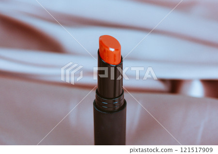Bright red lipstick in black tube on silky background. Cosmetics product high quality photo. Female beauty care products Vogue fashion women lifestyle Bright red lipstick in black tube on silky background. Cosmetics product high quality photo. Female beauty care products Vogue fashion women lifestyle 121517909