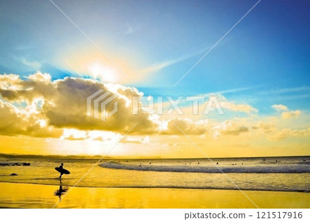 A surfer heading to the sea in the morning sun A surfer heading to the sea in the morning sun 121517916