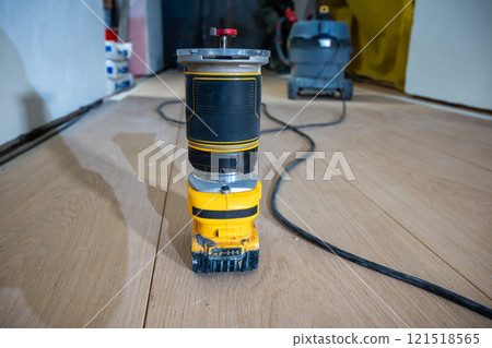 Close Up of Yellow and Black Router on Wooden Floor in Workshop 121518565