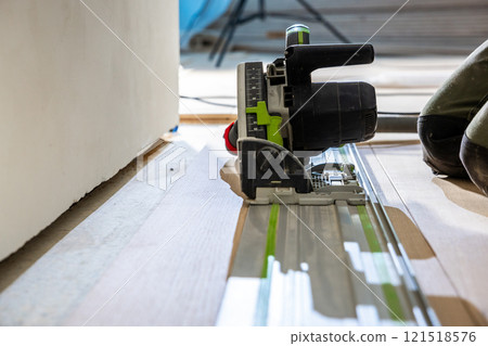 Close Up of Track Saw Cutting Wood Flooring on Guide Rail Close Up of Track Saw Cutting Wood Flooring on Guide Rail 121518576