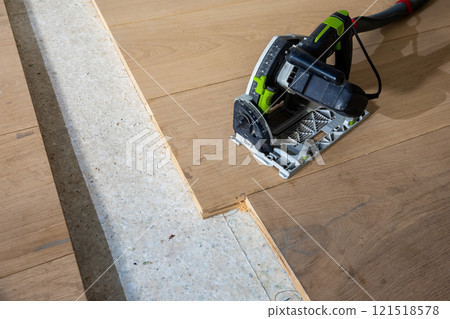 Close Up of Track Saw Cutting Wooden Planks on Indoor Floor Close Up of Track Saw Cutting Wooden Planks on Indoor Floor 121518578