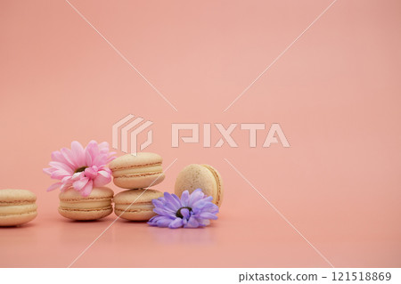 Round beautiful sweets macaroni with flowers on a pink background. Still life with macaroni cakes and different flower. Copy space. Banner Round beautiful sweets macaroni with flowers on a pink background. Still life with macaroni cakes and different flower. Copy space. Banner 121518869