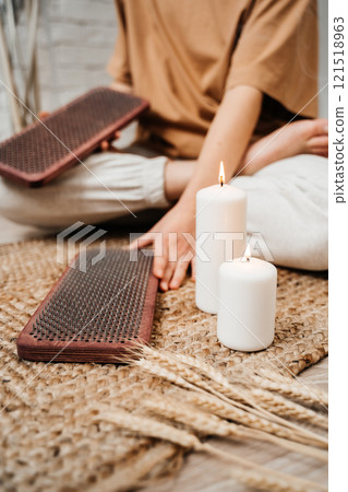 The girl is holding a Sadhu Board in her hands. Close-up. White candles. Concept on healthy lifestyle. 121518963