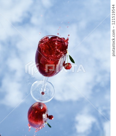 Cherry splashes into summer drink on bright sky background 121519544