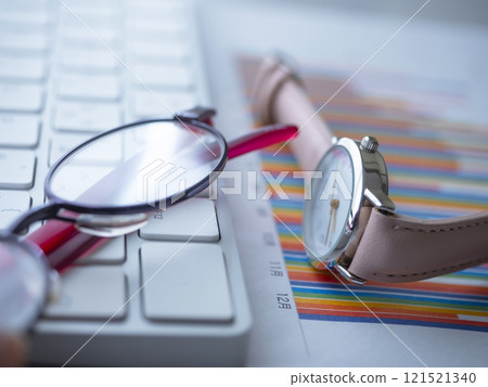 Graph, keyboard, glasses and watch on a table 121521340