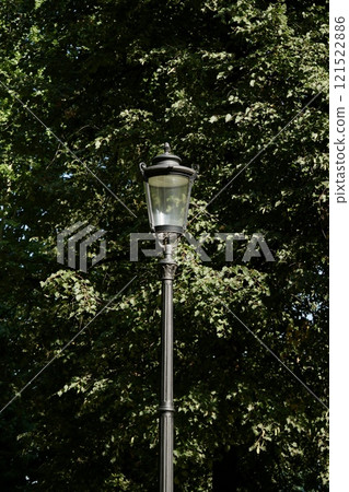 Vintage glass street lamp, lantern on high pole in park. Ideal for historical architecture 121522886