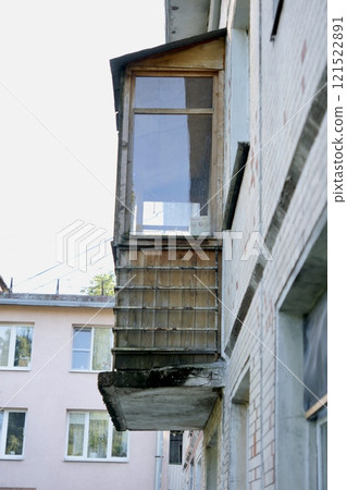 old balcony, facade of the house is in poor condition. dilapidated neighborhood of abandoned houses old balcony, facade of the house is in poor condition. dilapidated neighborhood of abandoned houses 121522891