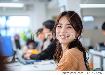 在熱鬧的工作場所工作的微笑的女人 121523297
