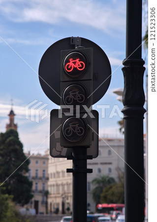 On the street there is a traffic light with the image of a bicycle 121523306