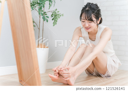微笑的年輕亞洲女性看著她的腳趾（拇囊炎、內生趾甲、香港腳、腳底、修腳） 121526141