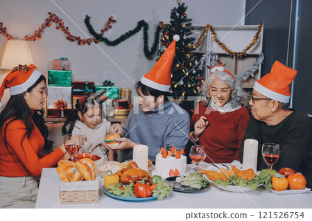 Happy multigeneration family enjoying in opening gifts on Christmas eve at home. Happy multigeneration family enjoying in opening gifts on Christmas eve at home. 121526754