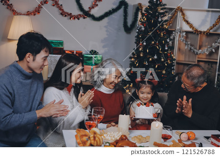 Multi-Generation Family Celebrate Christmas At Home Wearing Santa Hats And Antlers Opening Presents Multi-Generation Family Celebrate Christmas At Home Wearing Santa Hats And Antlers Opening Presents 121526788