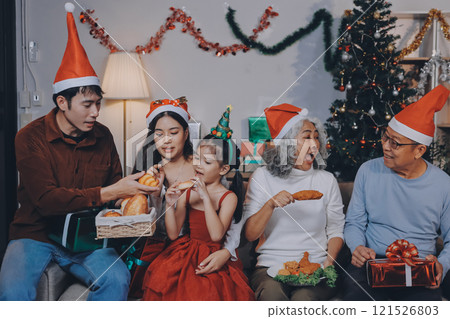 Portrait of Asian family exchanging presents during christmas at home. Attractive happy people holding gift box, celebrate holiday thanksgiving, xmas eve tradition in living room in house together. Portrait of Asian family exchanging presents during christmas at home. Attractive happy people holding gift box, celebrate holiday thanksgiving, xmas eve tradition in living room in house together. 121526803