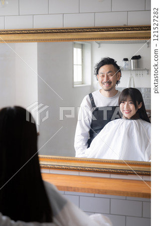 Image of a customer and a hairdresser getting their hair cut or cared for at a beauty salon 121527282