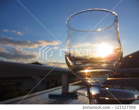 The light of the sunset shines through the wine glass 121527308