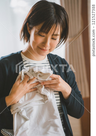 Young woman folding clothes 121527388